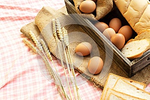 Morning food. breakfast and baked bread concept. Fresh fragrant bread and egg on the fabric sack. On wooden table