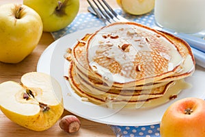 Morning food: pancakes with fresh apples, sweet syrup and almond