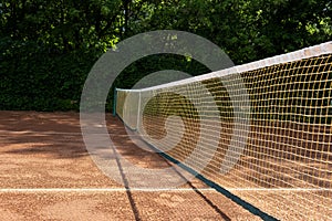 Morning. Fragment of an outdoor clay tennis court. Grid and marking lines visible. Sports background. Selective focus, design
