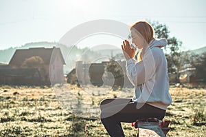 In the morning Girl closed her eyes, praying outdoors, Hands folded in prayer concept for faith, spirituality, religion concept.