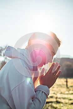 In the morning Girl closed her eyes, praying outdoors, Hands folded in prayer concept for faith, spirituality, religion concept.