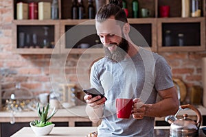 Morning habit man kitchen tea coffee check phone