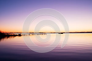 Morning in harbor. Tourists pier above sea. Sunny clear blue sky, smooth water level