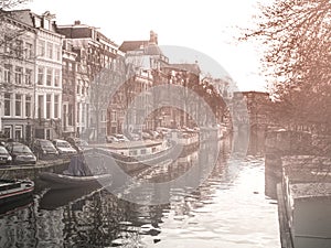 Morning haze at water canal, gracht, in Amsterdam, Netherlands.