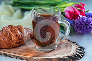 Morning herbal tea with thyme and croissant