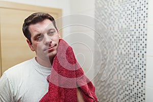 Morning hygiene, man with towel after shaving his beard