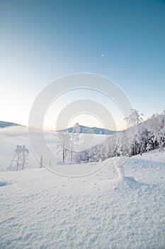 Morning idyll on the top of a snow-covered mountain with the rays of the sun irradiating the clouds, the ice cap of the mountain