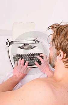 Morning inspiration concept. Guy create new chapter use typewriter. Writer author used to old fashioned machine instead