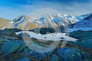 Morning in Italian Alps, mountains with small lake in the rock, hills in the clouds, Alp, Gran Paradiso, Italy.