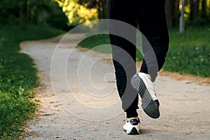 Morning jog in the park, men`s legs close-up copy space