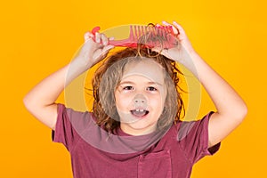 Morning kids after shower. Little kid combing hair, isolated studio background.