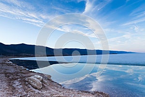 Morning landscape of lake Baikal with reflaction of blue sky in pure water.