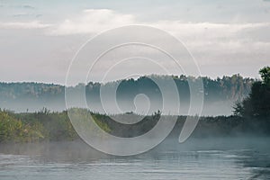 Morning landscape, sunrise and fog over the river and field.