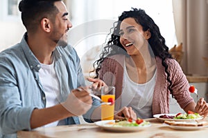 Morning Meal. Romantic Arab Couple Eating Breakfast, Chatting And Laughing In Kitchen