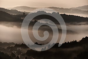 The morning mist covers the forested hills.