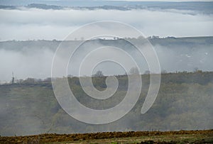 Morning mist defiling over the foggy hills