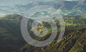 Morning mist in the mountain peaks on natural landscape. Green valley on background foggy dramatic sky. Panorama horizon perspect photo