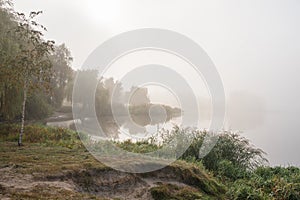 Morning mist over the lake with reflection in the water. Fog on a river