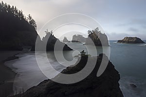 Morning mist over silhouetted rocky shoreline