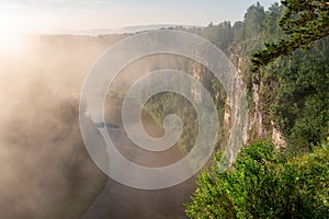 The morning mist rises over the river canyon