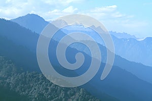 Morning mountain landscape with layer of mountain peaks covered