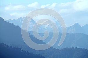 Morning mountain landscape with layer of mountain peaks covered