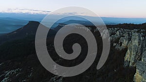 Morning mountain landscape with waves of fog. Shot. Top view of mountains in fog and rock at dusk. Mystic foggy