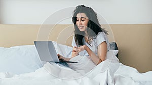 morning online video chat woman using laptop bed