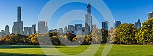 Morning panoramic view of the Central Park Sheep Meadow in Fall. View on the Midtown skyscrapers skyline. NYC