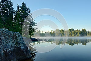 Morning Reflections on a Foggy Wilderness Lake