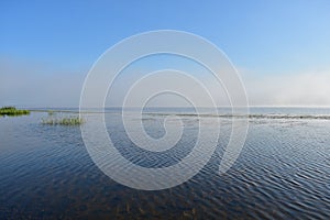 Morning river fog creeps over the water beautiful view blue sky clouds reflected in the water