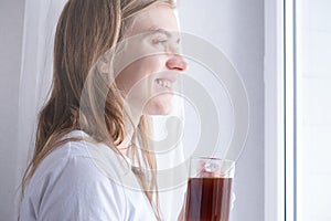 Woman Standing By Bedroom Window And drinking fresh coffee