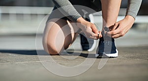 Morning running. Young man tying shoelaces on sneakers, on track