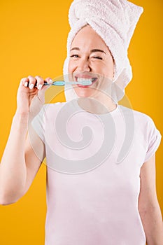 Morning rutine teeth brushing lovely woman on yellow background.