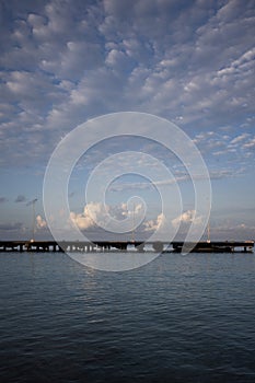 Morning seascape. The pier, the sea and soft clouds above it.