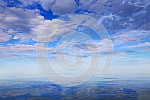 Morning seascape with reflection of the sky with clouds.