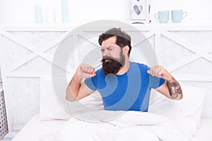 Morning sleepiness. peaceful mature male relaxing. bearded man stretching in bed. sleepy guy relax in bedroom. early