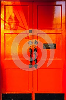 Morning sun painting over a bright red door in Dublin