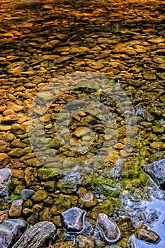 Morning sunlight on submerged rocks in Walden Beck, West Burton, North Yorkshire.