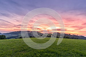 Morning sunrise in Beskyd area colored dark sky with clouds and fresh fog covering grass around mountains and hills behind in the