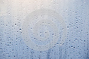 Morning sunrise through the raindrops on the glass. Condensation on Windows in the cold. Texture of the water