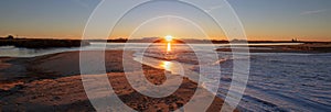 Morning sunrise reflections over tide outflow of the Santa Clara river at McGrath State Park on California`s Gold Coast USA