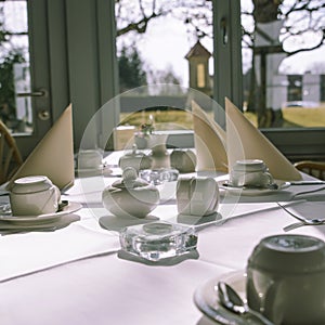 Morning table setting for breakfast from white tableware by the