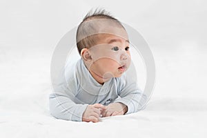 Morning Time.Adorable newborn kid during tummy time smiling happily at home.Portrait of cute smiling happy asian baby boy crawling