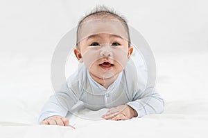 Morning Time.Adorable newborn kid during tummy time smiling happily at home.Portrait of cute smiling happy asian baby boy crawling