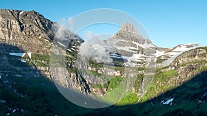 a morning time lapse shot of mist clearing from mt oberlin and logan pass at glacier national park