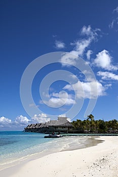 Morning on the tropical island landscape - huts on piles, the sea