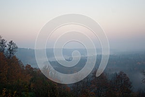 Morning view with fog on hills and forest in autumn day in Latvia