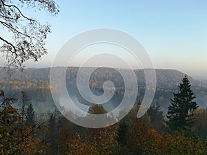 Morning view with fog on hills and forest in autumn day in Latvia