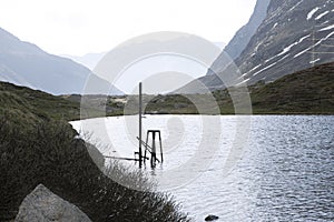 Morning view on small mountain lake and surrounding nature, swiss alps high mountain range, grisons canton by spring